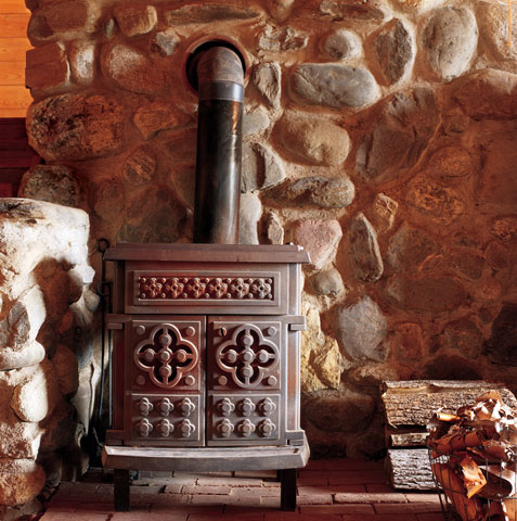 Kate bought the Amity woodstove (the company’s now out of business) in the early 1980s, when high oil prices were forcing many people to seek out heating alternatives. “I love the aesthetics of it, the pattern on the front,” she says. The chimneys from the woodstove and the kitchen cookstove are encased in a massive interior stone wall; the radiant heat from the wall warms the upstairs room as well. In winter, the sun reaches almost to the back northern wall; Kate uses only four cords of wood each year to keep the home toasty.